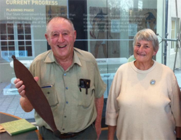 Dick and Rita Roberts holding one of the donated spearthrowers at the WA Museum.
